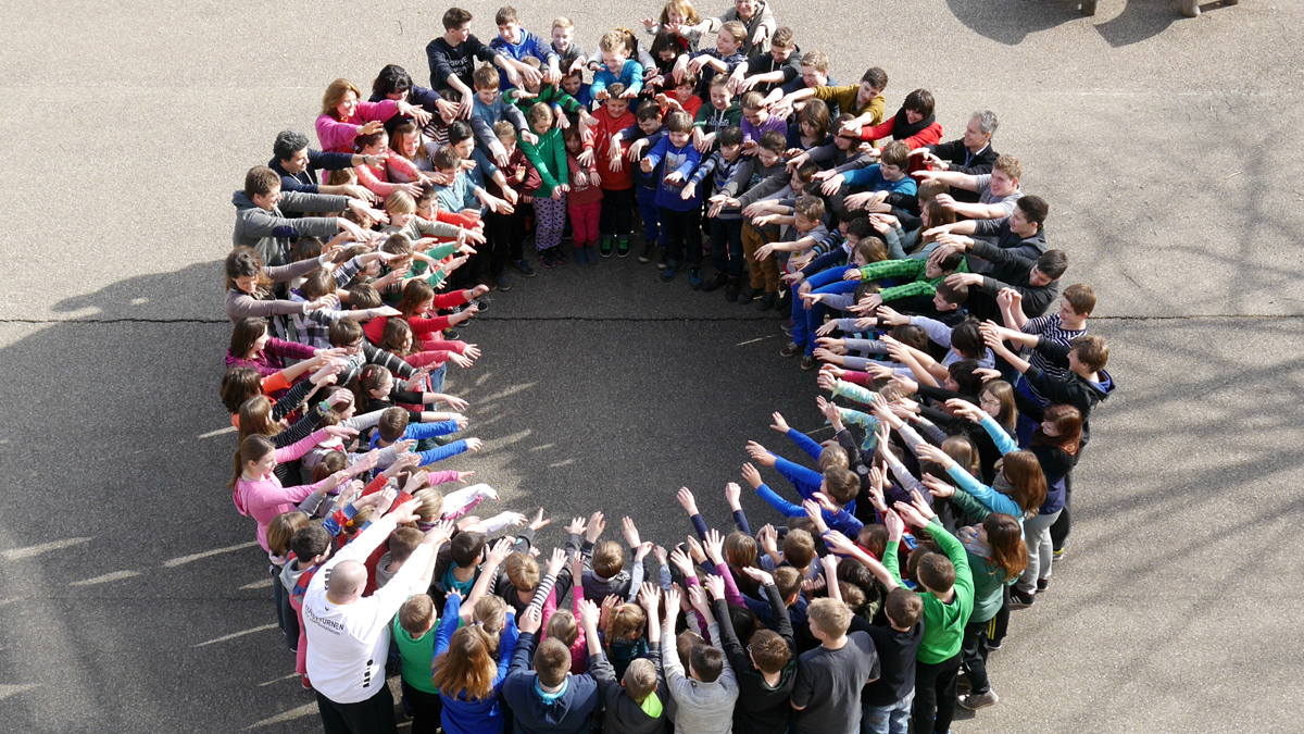 Schüler*innen in großem Kreis auf dem Schulhof